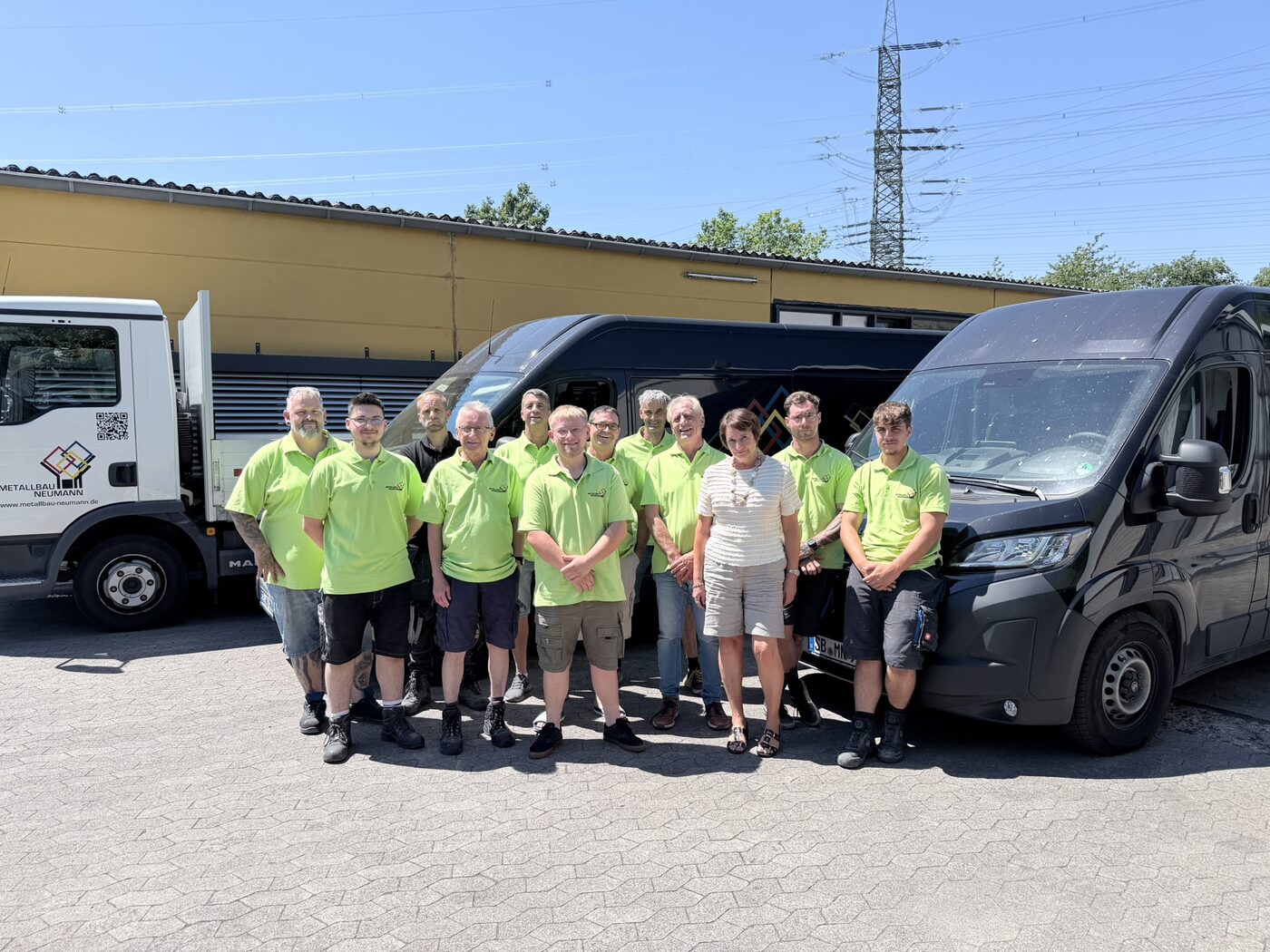 Das Team von Metallbau Neumann vor dem Fuhrpark